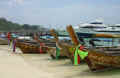 Long-tails on the beach at Phi Phi Don with flags to ward off evil spirits